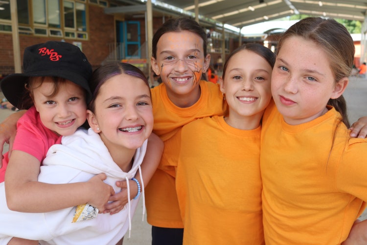 Five students dressed in orange
