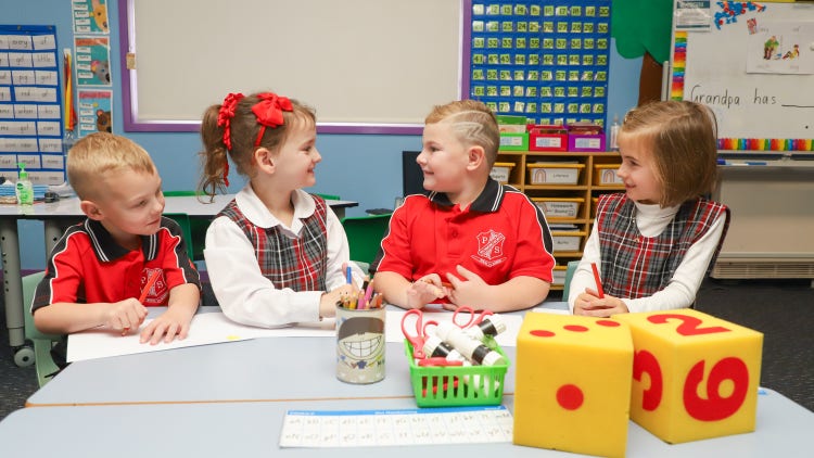 four students sitting at classroom table
